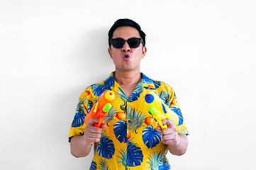 Thai male holding two blurred focus of water guns wearing yellow shirt for Thailand Songkran festival concept.