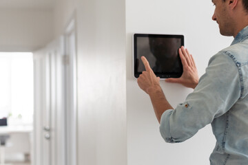 man watching delivery man on security camera cctv video on tablet