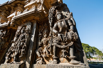 The Hoysaleshwara temple features detailed stone carvings of deities, reflecting exquisite artistry...