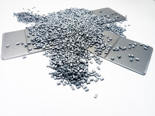 Gray masterbatch granules with color chip, polymer carries pigment poured into a white background,...