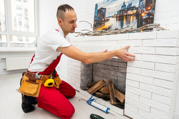 Professional technician installing electric fireplace in room