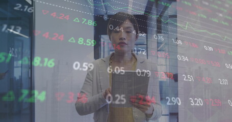 Image of financial data processing over asian businesswoman using tablet in office