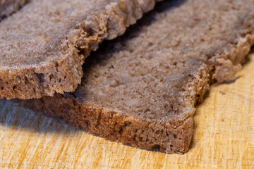 Brotscheiben liegen auf einem Holzbrett, Vollkornbrot, Nahaufnahme, Studio