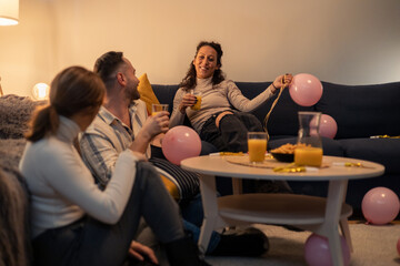 Friends celebrating with balloons and drinks at home party