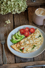 Omelette with spinach, tomato and cheese. Avocado and cherry tomatoes