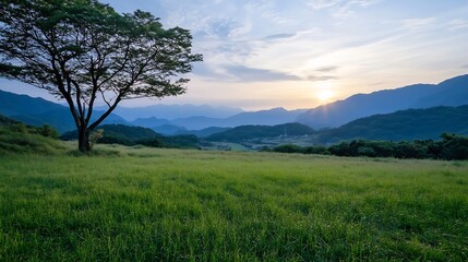 Fototapeta premium Lush Green Valley with Majestic Mountains and a Single Tree at Sunrise : Generative AI
