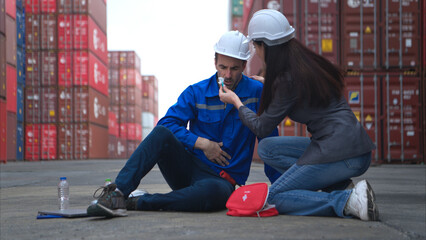 First aid for a container warehouse worker fainted while working in the bright sunlight