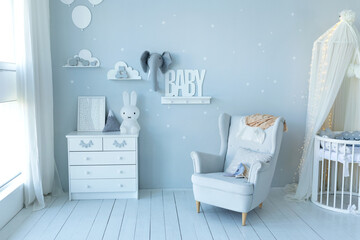 Stylish skandi interior of newborn baby room with bed, grey armchair and wooden dresser with toy and picture. Decor children room with furniture. Crib in a modern nursery room. Baby cot with canopy   © stock_studio