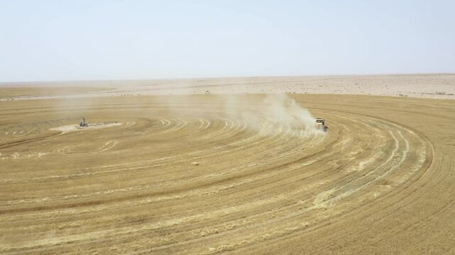 Golden wheat stretches across the vast field as a large machine efficiently harvests the crop under bright summer sunlight. This is a part of a several projects to exploit desert areas in Iraq.