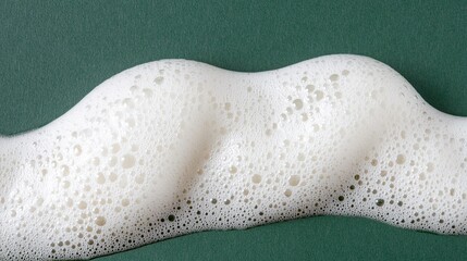 Obraz premium White foam texture on green background, close-up
