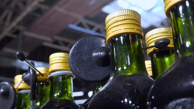 Bottles of olive oil or other liquids, standing in a row, with anti-theft systems in the store - radio frequency sensors that are triggered when exiting. Protection of goods from theft. Theft in shops
