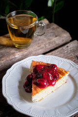 a piece of cheesecake with cherry sauce. cottage cheese casserole.
