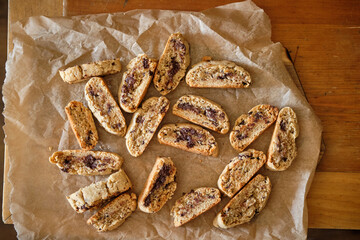 Biscotti with chocolate on a wooden board, top view.