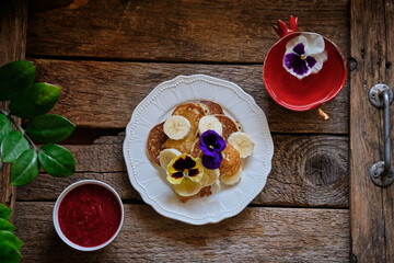pancakes with edible flowers. Wooden background, top view.	
