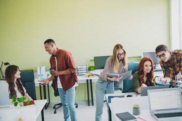 Photo of group young corporate workers conversation drink coffee use computer workstation office...