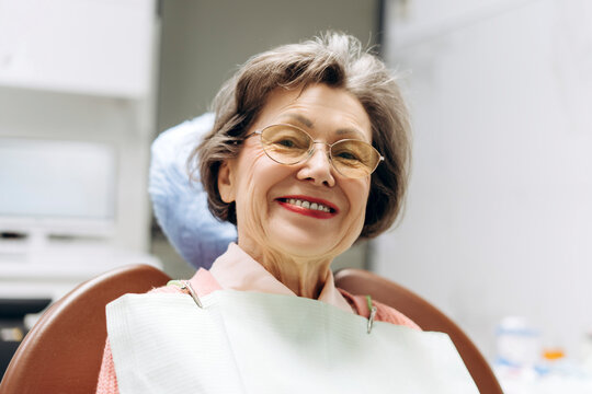Senior woman smiling during dental checkup: oral health in old age - Powered by Adobe