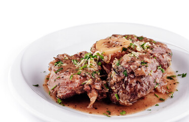 Delicious braised osso buco with gremolata on white plate