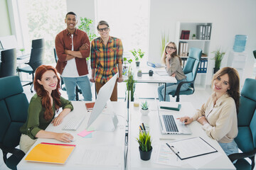 Photo of group five young corporate workers crossed arms computer desk workstation office business...
