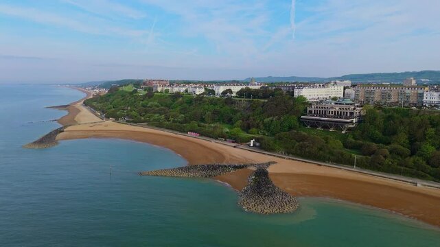 Rocky outcrop forms V-shape at Folkestone sandy beach. Aerial panning