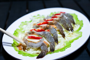 Shrimp soaked in fish sauce spicy in white plate, salty and sour Thai appetizers.