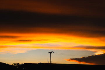 Naklejka premium Golden moody clouds by the rays of the dawn sun after sun has just set behind.