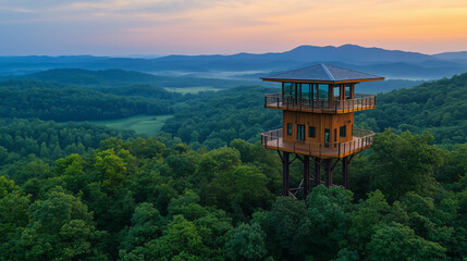 Scenic lookout tower stands tall amidst lush green hills during a vibrant sunset, offering breathtaking views of the surrounding nature and mountains in the distance