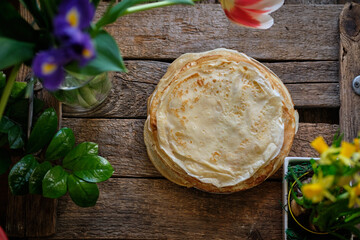 crepes. top view, wooden background, spring flowers, Maslenitsa.