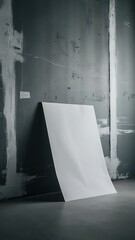 Blank White Paper Poster Leaning on Grunge Gray Studio Room Wall as Copy Space for Design and Template Mock up for Adding Your Text.