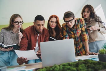 Photo of young age team students colleagues diverse guys and girls making money crypto currency using laptop at office