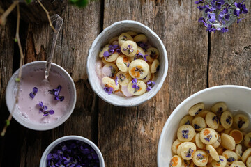 Mini pancakes with cream sauce decorated with wild violets. Spring.