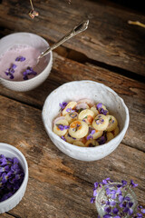 Mini pancakes with cream sauce decorated with wild violets. Spring.