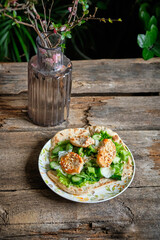 flatbread with lettuce, chicken, cucumber and nuts. Wooden background, side view	
