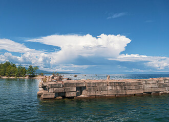 Clouds loom over a tranquil lakeside pier in a serene afternoon landscape