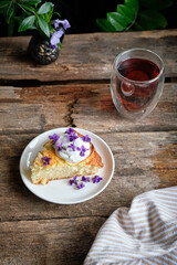 a piece of cake with cream and edible flowers.