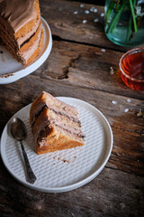piece of walnut cake with prunes and chocolate decorated with edible flowers. spring.
