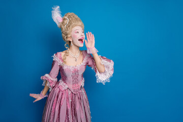 Young woman in an elegant baroque dress with playful expression against a vibrant blue background