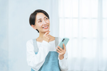 スマホ、女性、考える、笑顔、エプロン、主婦、アルバイト、パート、求人、検索、SNS、アプリ、メール、期待、希望、楽しみ、チャンス、セール、クーポン、ポイント、プレゼント、キャンペーン、予約、コピースペース、ワクワク、スマートフォン、ネット、オンライン、web、店員、ショップ、家事代行、室内、インテリア、見積もり、副業、資格、ミドルエイジ、ラッキー、日本人、仕事、清掃、家事、便利、お得、おトク、口コ