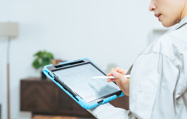 タブレット、設計、図面、建築、女性、作業員、エンジニア、点検、メンテナンス、間取り、不動産、検査、DX、IIoT、改装、内装、建設、ゼネコン、住宅、住まい、インテリア、コーディネーター、仕事、プロフェッショナル、消防、修理、修繕、管理、店舗、測量、計測、アプリ、システム、CAD、ペーパーレス、電子化、見える化、家具、レイアウト、チェック、確認、日本人、ミドルエイジ、作業服、工事、現場、IT、設計図