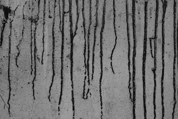gray background, photo shows texture of concrete wall and black paint streaks