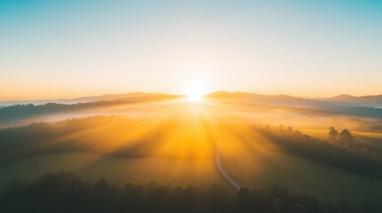 Obraz premium Golden sunrise over misty mountains and lush green valley
