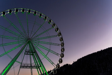 Ferris wheel among snowy mountains