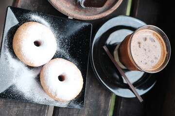Fresh donuts sprinkled with powdered sugar, perfect for breakfast or a sweet snack.