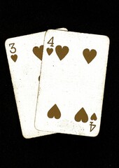 A blackjack or pontoon hand of old playing cards in sepia on a black background.