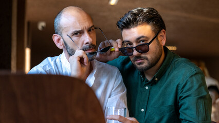 Two middle-aged businessmen in office attire are enjoying their time together at a café outside the office