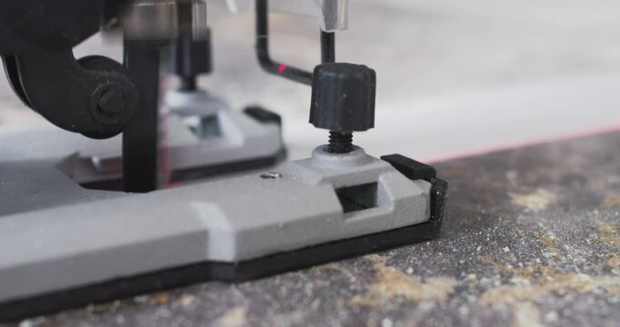 Jigsaw cutting wood plank, close up view of blade in action