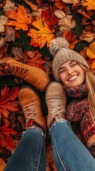 Fototapeta premium Woman relaxing on autumn leaves, enjoying nature, view from above. Possible use stock photo for fall theme