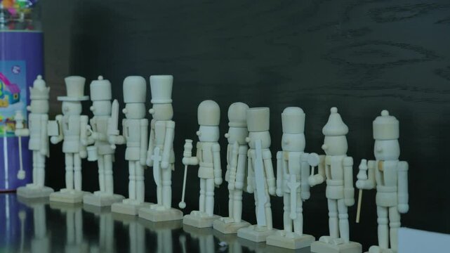 A close-up lineup of blank wooden nutcracker soldiers.
