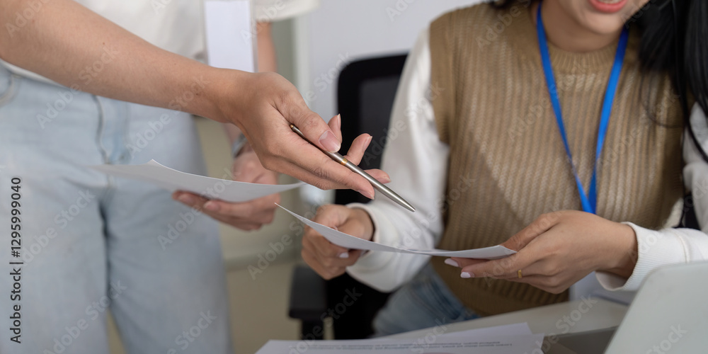 Poster colleagues exchanging documents and discussing financial reports in a collaborative environment.