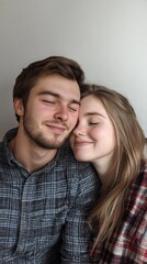Obraz premium Happy young caucasian couple embracing with eyes closed in plaid shirts Date Your Mate Month