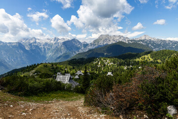 Fototapeta premium Velika Planina, Kamnik, Slovenia. Lord of the Rings style village. Wooden typical houses, hills, green meadows, flowers where cows and calfs graze. High quality artisanal milk and cheeses. Holiday.